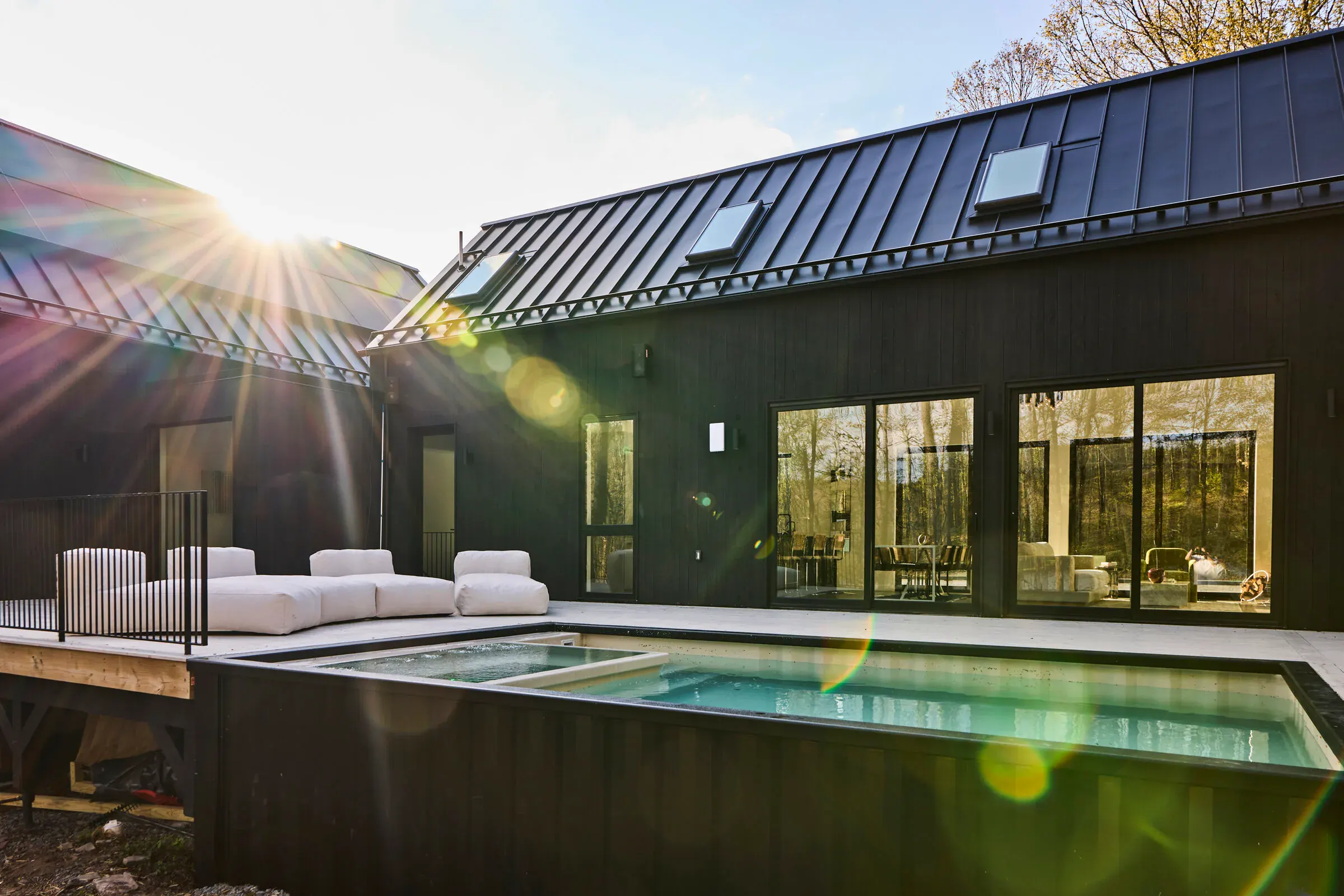 Verdant Sound pool deck at golden hour — hot tub pool surrounded by the Catskills forest